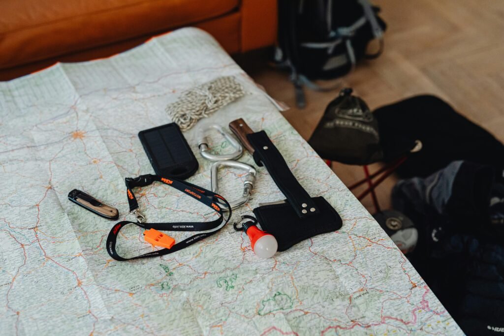 Hiking Gear Essentials. A collection of travel tools and gear laid out on a map, ready for an outdoor adventure.