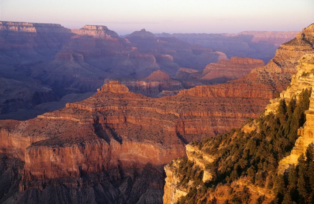Stunning view of the Grand Canyon's eroded rock formations at sunset, showcasing nature's grandeur.