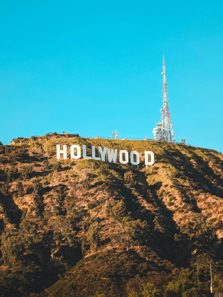The famous Hollywood sign perched on the hills of Los Angeles under a clear blue sky.