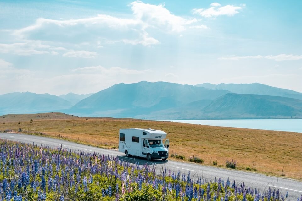 white van on road near green grass field during daytime